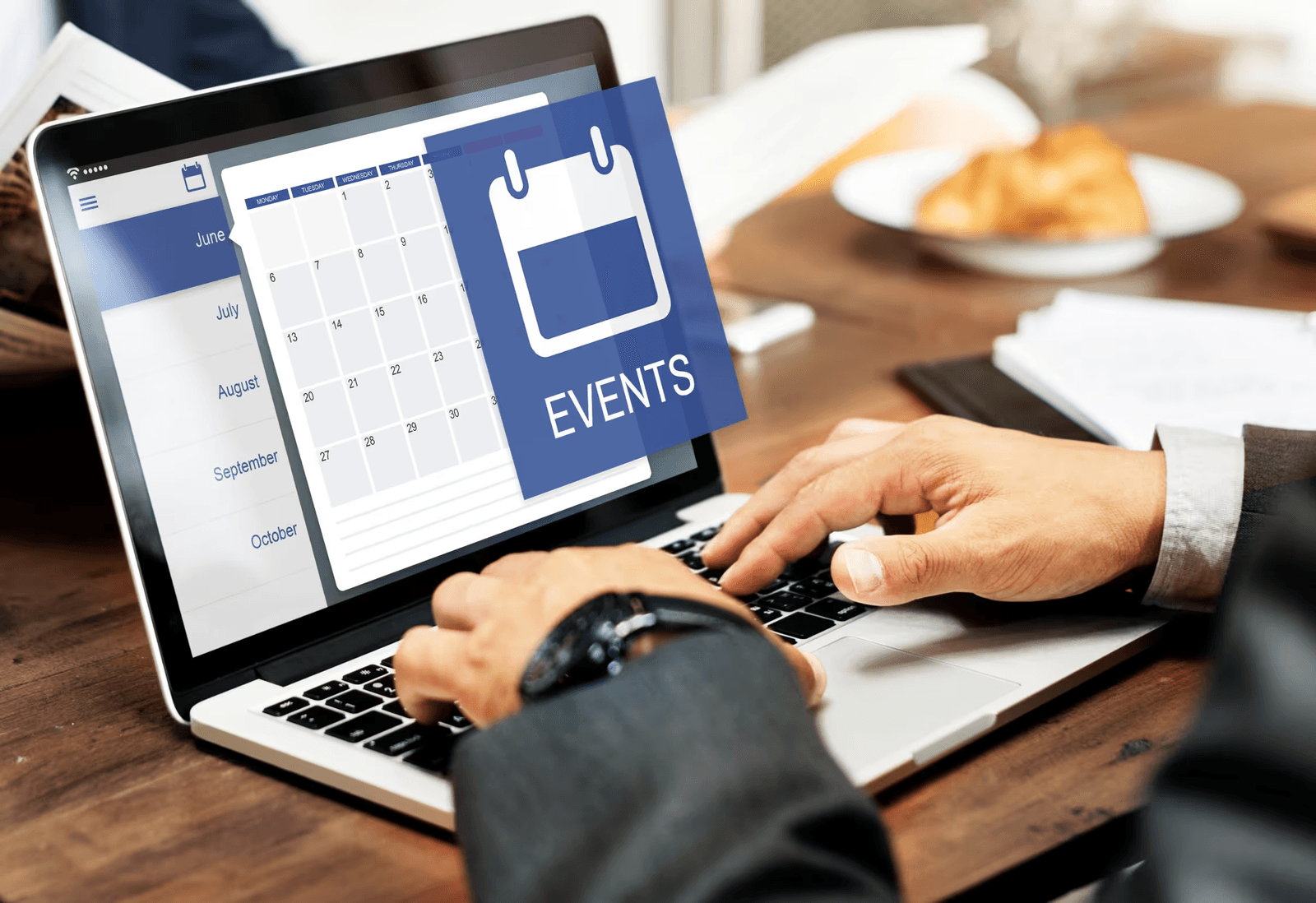 Professional managing a digital events calendar on a laptop