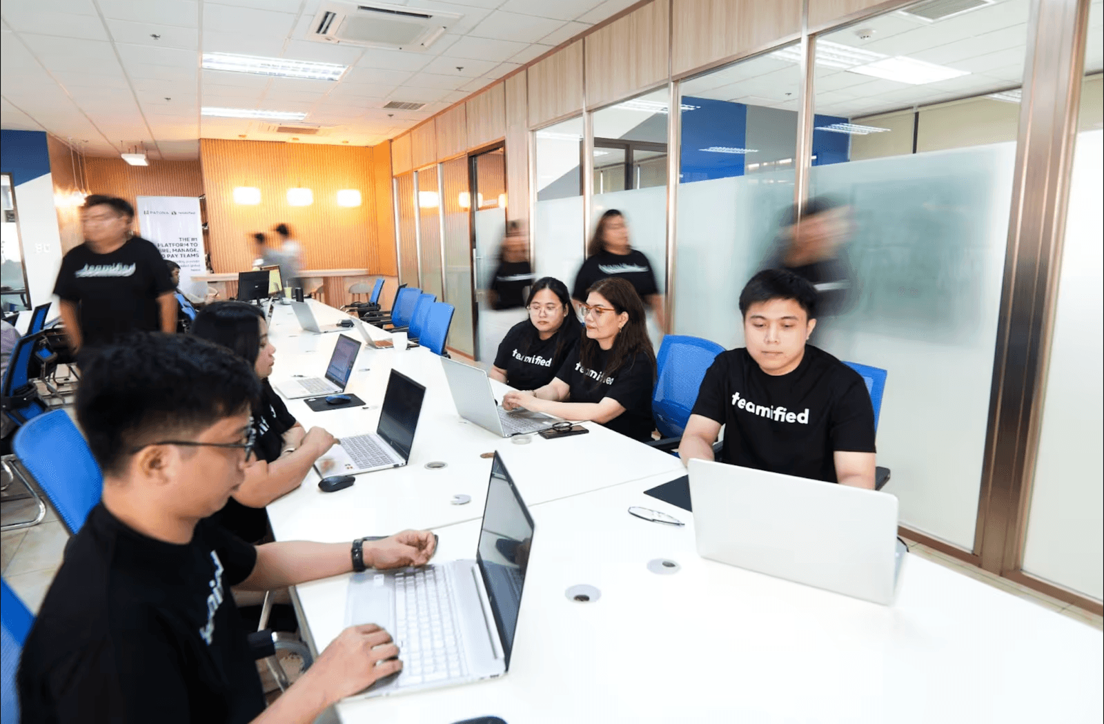Teamified customer support team working on laptops in the office